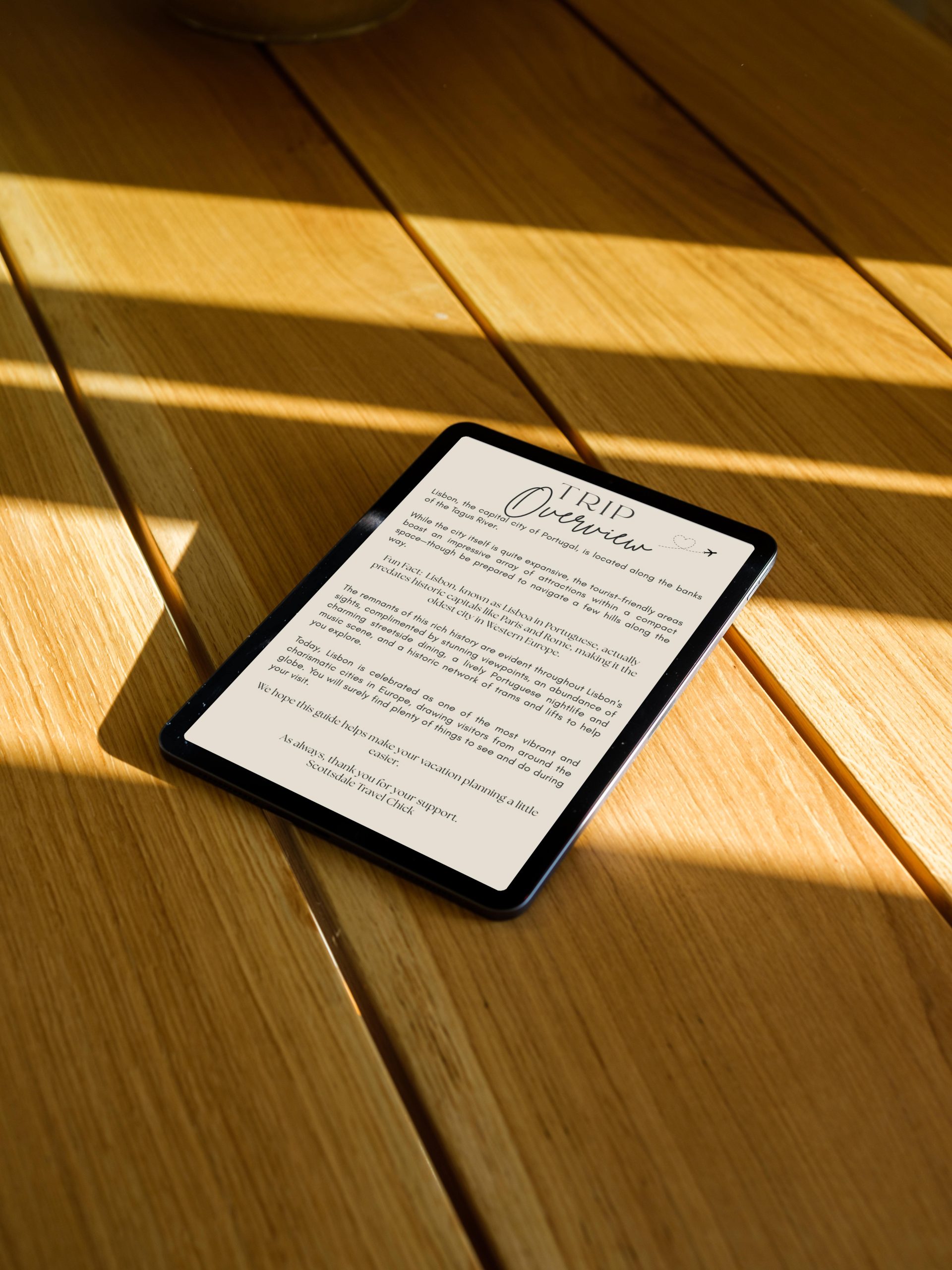 Tablet displaying trip overview on wooden table.